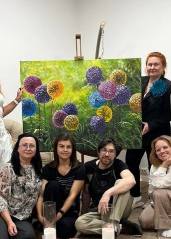 Pigmentori team posing with a colorful painting in a room.
